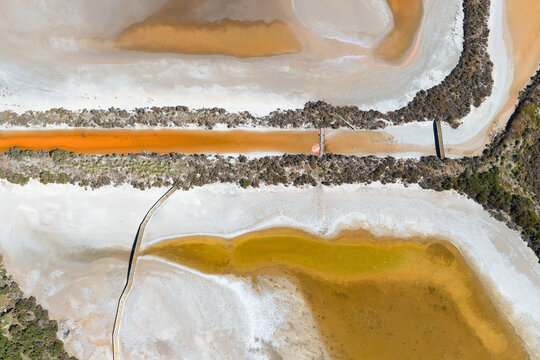 Wooden bridges and vegetation around the edges of drying salt ponds