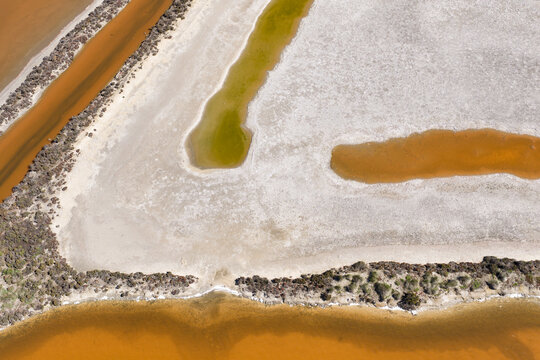 Crusty salt deposits around the edges of colorful salt lakes 