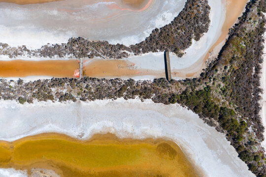 Wooden bridges and vegetation around the edges of drying salt ponds
