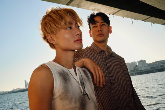 Two stylish young men standing by Hangang River in Seoul