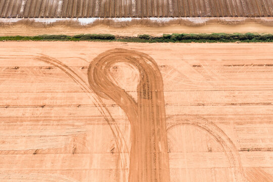 Circular wheel tracks in rich soil of a market garden field