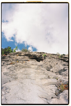 Low angle of rocky limestone slope against cloudy sky
