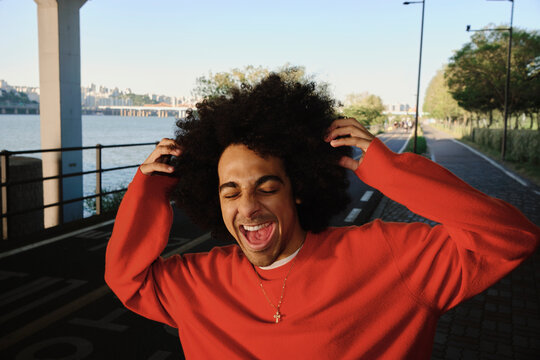 Young man laughing by Hangang River pathway in Seoul
