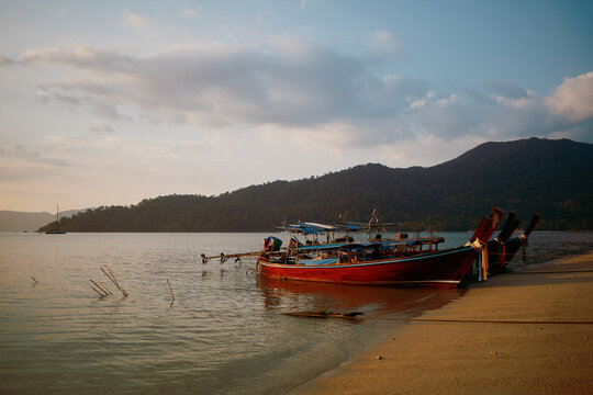 Long tail boat anchored near shore on a calm day on a Thai island