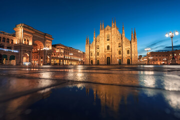 Fototapeta premium Illuminated Facade Duomo di Milano and Galleria Vittorio Emanuele II with water reflection in Piazza del Duomo, Milan