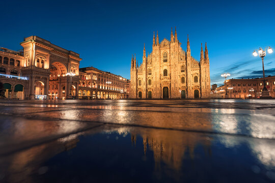Illuminated Facade Duomo di Milano and Galleria Vittorio Emanuele II with water reflection in Piazza del Duomo, Milan