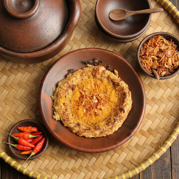 Kerak Telor Indonesian Traditional Spicy Omelette Served on Clay Plate, Jakarta Street Food with Serundeng and Fried Shallots on Woven Bamboo Tray with Red Bird Eye Chilies, Flat Lay