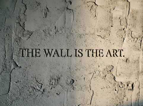 Inspirational quote carved into textured concrete wall surface