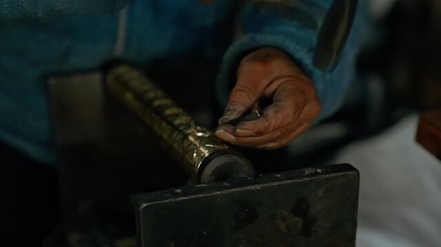 Coppersmith processing a large copper vessel by hammering it in slow motion. Cinematic view of master creating handmade traditional metal art.