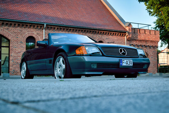 Classic Mercedes 300SL Convertible Parked in Front of Historic Brick Building at Sunset