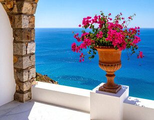 Naklejka premium Vibrant pink bougainvillea flowers in a classic terracotta urn sit on a white balcony, overlooking the breathtaking, peaceful turquoise Mediterranean Sea on a sunny summer day.