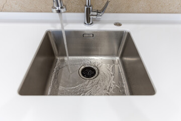 Fototapeta premium Stainless kitchen sink with food waste disposal in modern home