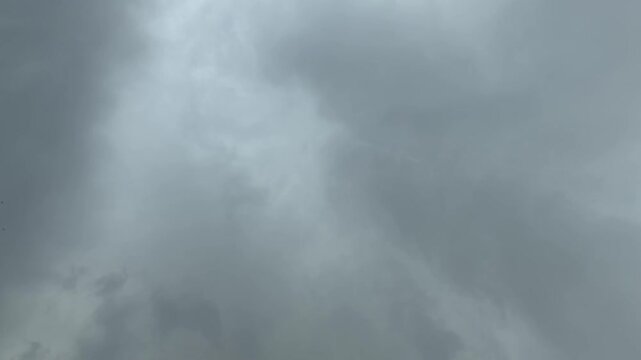 Dark, heavy storm clouds completely blanket the sky, signaling imminent rain and turbulent weather.