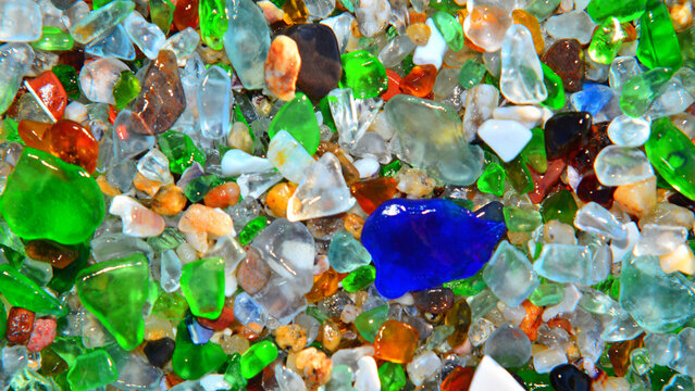 A multicoloured background of pieces of glass washed up on the beach. The photograph was taken exactly as the pieces of glass were found, without touching or moving them.