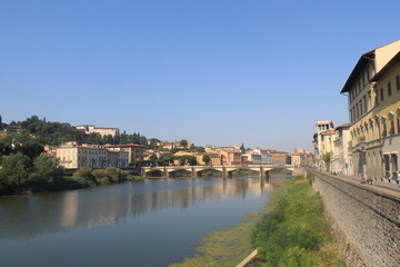 Naklejka premium Beautiful sunset illumination over the Arno River showcasing stunning architecture in Florence, Italy