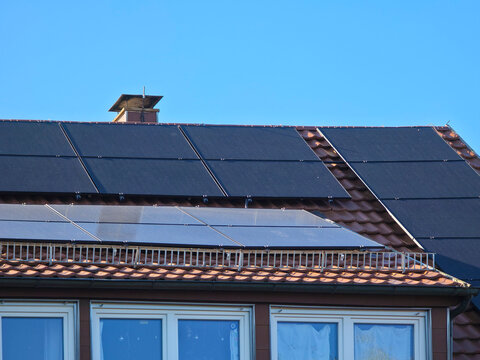 impressive residential solar array on red roof maximizing clean energy production under vibrant deep blue sky