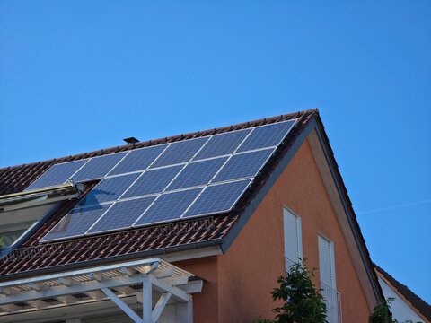 extensive pv module installation on orange house roof generating sustainable power under magnificent blue sky