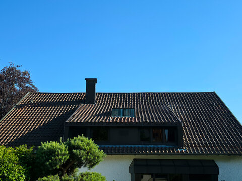 empty residential roof awaiting future possibilities beneath pristine blue sky and bright sunshine