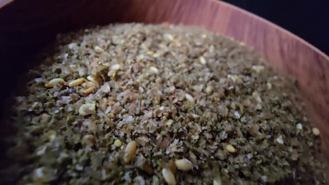 Close-up shot of a bowl filled with high-quality traditional za'atar spice mix, featuring toasted sesame seeds and aromatic dried herbs, gourmet middle eastern culinary ingredient, textured food backg