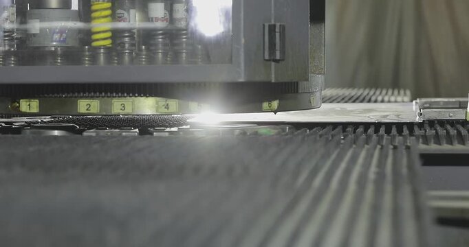 CNC Turret Punch Press Processing Aluminum Sheet Metal. Precision Metal Engraving on Automated Punch Press. Coordination punching press, CNC, coordinate press. Close-up.