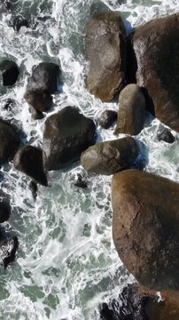Tropical beach with waves hitting on the rocks at Brazil