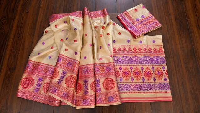 Traditional silk dress with intricate patterns laid flat on a wooden floor.