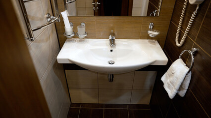 Fototapeta premium Modern bathroom interior with white ceramic sink and chrome fixtures