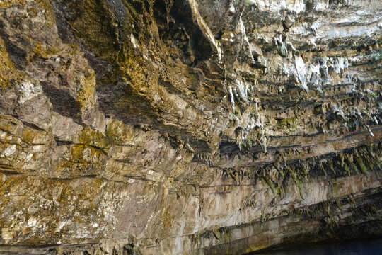 Structural rock wall with water trails inside Melissani Cave