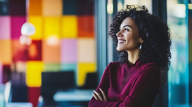 Happy woman with curly hair looking out window.