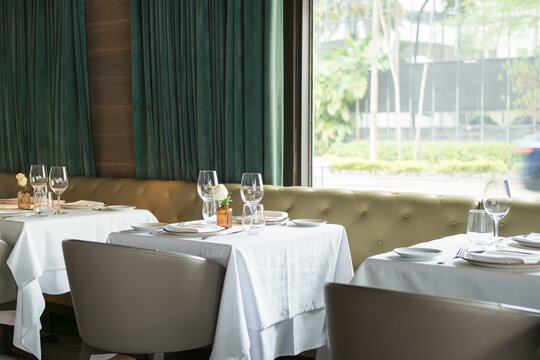 Upscale Dining Room with Natural Light and Elegant Table Settings
