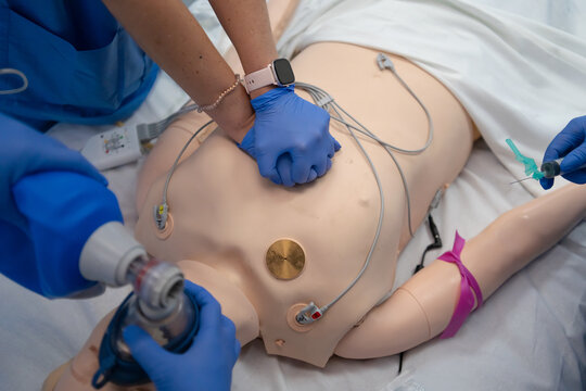 Medical professionals performing crp on training mannequin