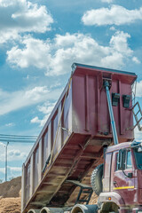 Heavy duty dumper truck with raised red tipper body unloading ca © kalyanby