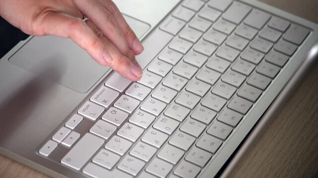 Close-up video of female hands typing on a white laptop keyboard, showing focused work, modern technology, productivity and digital lifestyle concept.
