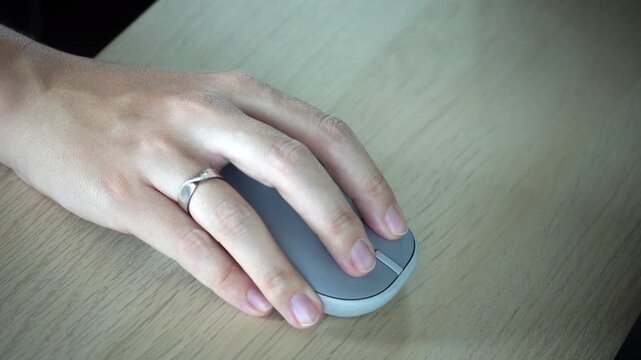 Close-up video of a female hand using a wireless mouse on a desk, showing focused work, modern technology, navigation, productivity and digital lifestyle concept.