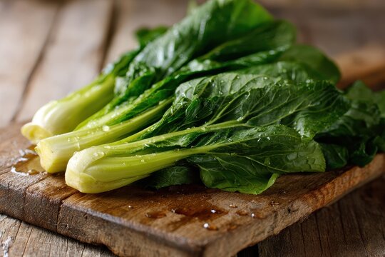 Fresh choy sum greens on a rustic wooden board under natural light