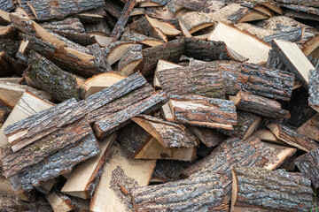 Fototapeta premium A large pile of freshly split logs with rough, textured bark