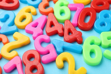Fototapeta premium Colorful numbers on light blue background, closeup