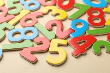 Fototapeta premium Different colorful numbers on beige background, closeup