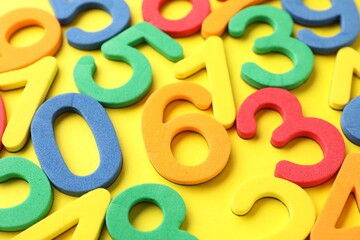 Fototapeta premium Different colorful numbers on yellow background, closeup