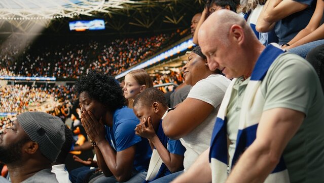 Disappointed soccer supporters reacting to missed chance during tense football match, filled with hope and tension in the stadium stands, Worried fans speechless and holding breath, last chance.