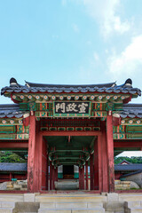 Fototapeta premium Traditional Seonjeongmun Gate with Hanja signboard and symmetrical corridor at Changdeokgung Palace, Seoul, South Korea.