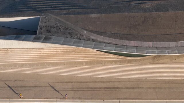 Aerial view of the modern MAAT museum with its curved architecture and people walking along the waterfront promenade in Lisbon, Lisbon, Portugal.