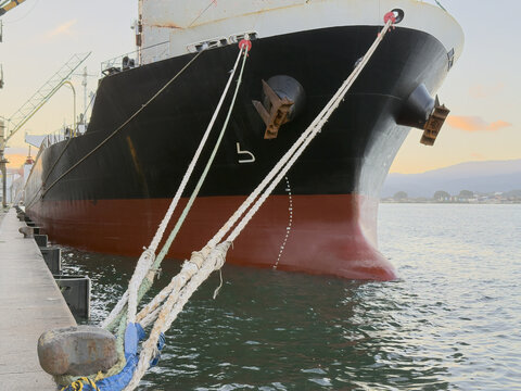 bulk carrier vessel moored in port. ship bow and bulb. mooring lines and anchors.