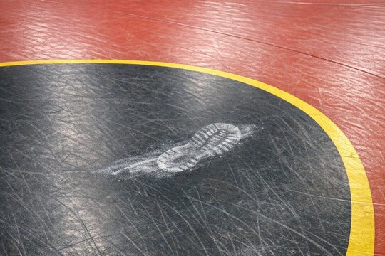 Close-up view of a wrestling mat featuring a white imprint