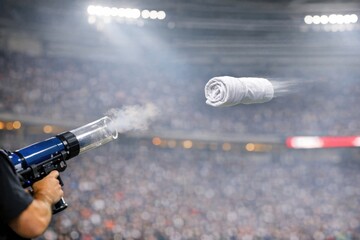 Obraz premium A person holding a gun with a towel wrapped around the barrel, providing a unique and intriguing scene