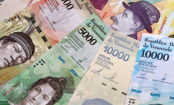 Venezuelan bolivar money bills pile on table. Venezuela banknotes of VES currency close up.