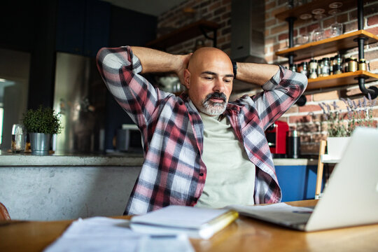 Middle-aged man working from home in kitchen