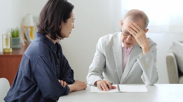 ノートに記入する高齢者の男性