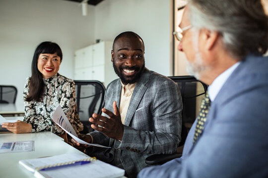 Smiling business team discussing reports in modern office