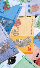 Malaysian ringgit money bills pile on table. Malaysia banknotes of MYR currency close up. © Larysa